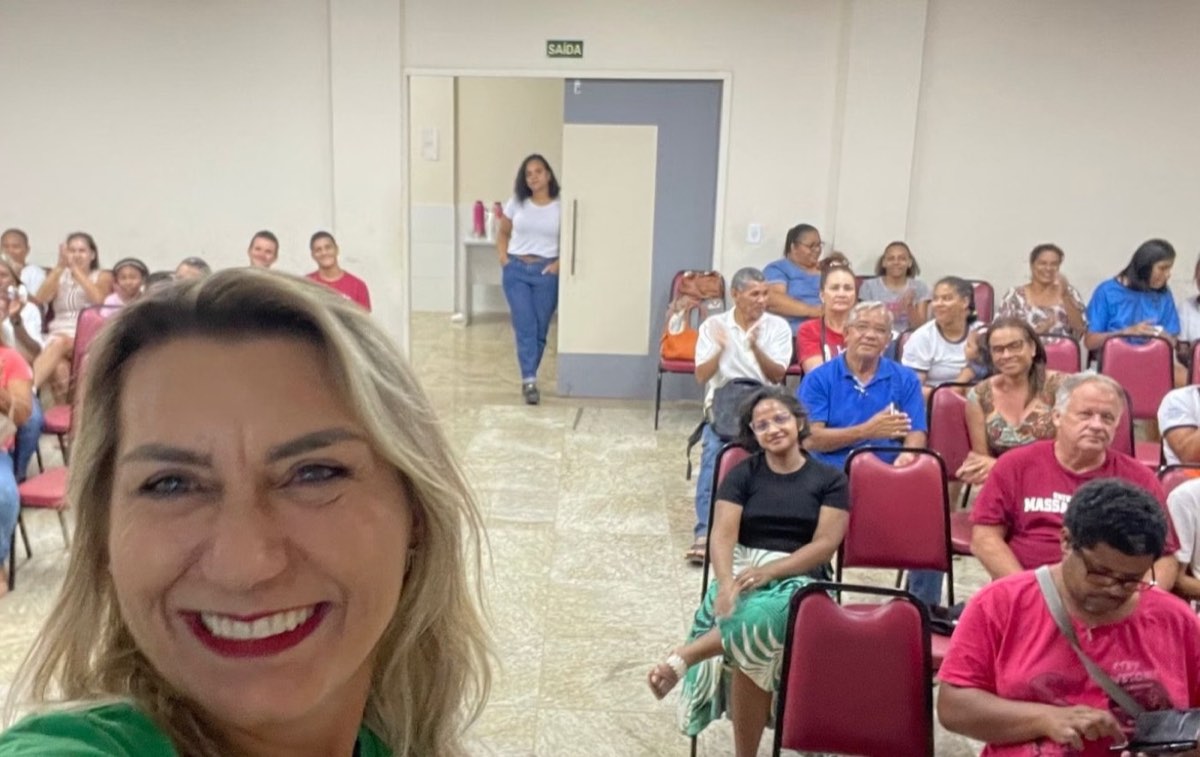 Cristine Aoni em uma capacitação, com o grupo ao fundo